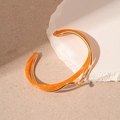 Detail of double-layer open bangle with orange resin and gold-plated geometric circles - Bright Orange (Gold Edge)