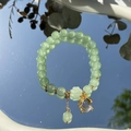 Elegant beaded bracelet with green gemstones and gold accents on a reflective surface - S048-firefly Donglin Jade Beaded Bracelet #sz344