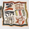 Detailed pattern of a silk-like square scarf featuring equestrian straps and a saddle - Apricot Saddle
