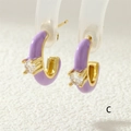 Dettaglio macro di orecchino a C in smalto viola con base dorata e zircone - Viola