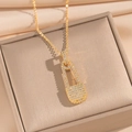 Macro shot of gold safety pin necklace with pavé cubic zirconia in a jewelry box - Gold Safety Pin Necklace (835)