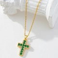Gold cross necklace with green and white cubic zirconia pendant on white pedestal - Gold/Green & White Gemstone Cross/S