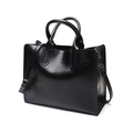 Detail view of a black glossy PU leather tote bag with sturdy handles and shoulder strap - Black