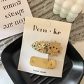 Set di fermagli per capelli dorati glitterati con stella sorridente su cartoncino - Sole + Quadrato