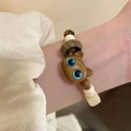 Handmade beaded bracelet with wooden cat head charm and blue eyes on a female wrist - Brown Cat Bracelet (1pc)