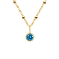 Golden beaded chain necklace with a round faceted blue gemstone pendant on white background - December Lake Blue - Gold