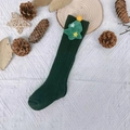Detail view of dark green knit Christmas socks with 3D tree and star on white fabric - Christmas Green - Pom Christmas Tree
