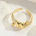 Detailed close-up of golden adjustable ring with sparkling zircon and circular motifs - Wrapped Style