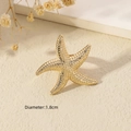 Detailed close-up of golden starfish open ring with diameter measurements on warm texture - Gold - Starfish Style