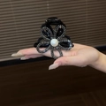Detalle de pinza para pelo de girasol con pedrería gris y una gran perla en el centro - Negro