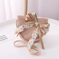 Close-up of pink straw crossbody bag with floral bow and ribbon for summer beach outings - One Size / Pink Bag