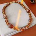 Close-up of marble-textured beads and golden spacers on a vintage beaded necklace - Necklace-Coffee Round