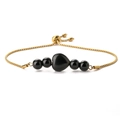 Detailed macro view of a 14K gold-plated heart bracelet with black beads and a slider clasp - Glossy Black Stone Bracelet