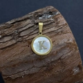 Golden round pendant with natural shell inlay and letter K on rustic wood surface - Letter K / 17x20mm