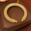 Detail of gold open bangle with pavé crystals on a leather jewelry case - Gold