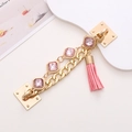 Golden alloy phone chain with pink square gemstones and tassel on a light pink surface - Gem Bracelet Tassel (Pink)