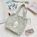 Detail der salbeigrünen Nylon-Tragetasche mit süßer Schaf-Stickerei und rotem Seitenetikett - Hellgrau