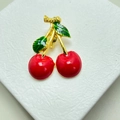 Macro detail of red enamel cherry brooch with green leaves and golden metal stem - Style 9 Rhinestone Cherry
