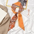Orange silk twilly with horse and geometric print tied in a bow for hair styling - Space Horse Caramel Orange