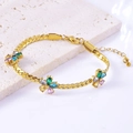 Detalle de la pulsera de flores doradas con circonitas de colores sobre base de piedra - Pulsera
