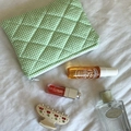 Close-up of green gingham quilted cosmetic bag with cherry hair claw on soft white fabric - Lipstick Pouch / Green Plaid