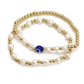 Detail of beaded bracelets featuring golden beads, freshwater pearls and blue evil eye - Layered Freshwater Pearl Gold Bead Blue Eye Style (BE843MI02)