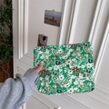 Detailed view of floral cotton makeup bag held by hand in a natural lifestyle setting - Dark Green White Flower