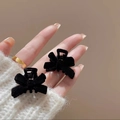 Set of two mini black flocked velvet bow hair clips shown against a cozy knit sweater - Hair Claw / Black Small Claw Clip