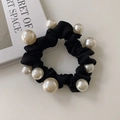 Macro detail of black satin scrunchie featuring elegant white pearls on a white surface - Black