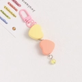 Close-up of heart-shaped keychain with pink metal clasp and matte resin pendants - Pink and Yellow Hearts