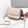 Piccola borsa a tracolla minimalista beige e bianca con un grazioso ciondolo a orsetto - Cachi