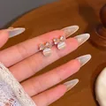 Elegant gold bow earrings with shimmering zircons and white cat eye stone beads - Gold Zircon Bow White Opal Stud Earrings