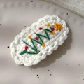 Close-up of hand-knitted Christmas tree hair clip with embroidery on white ceramic plate - 26228B White Base Christmas Tree BB Clip