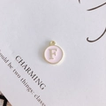 Detailed view of round pink enamel pendant with gold letter F for DIY jewelry making - Letter F