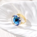 Luxury gold adjustable ring with a large blue round faceted crystal on ceramic tray - Adjustable Open / Blue Round