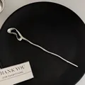 Polished silver wave hairpin with minimalist fluid metal design on a black plate - Cloud Hairpin Silver