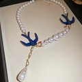 Detailed view of pearl necklace with blue swallow charms and a teardrop pearl pendant - Necklace - White - Blue - Low Quality