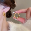 Detail of twisted gold hoop earrings with diamond-cut texture on a model's ear - 31# Ear Buckle - Gold Faceted Twisted