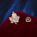 Classic golden maple leaf lapel pin badge displayed on luxury red velvet cushion - Gold Maple Leaf