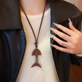 Detail view of brown leather fishbone pendant necklace worn over a black leather jacket - 38# Coffee