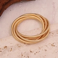 Gold multi-layer spring cuff bracelet on a natural stone surface with a modern metal finish - Gold