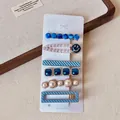 Detail view of a 6-piece blue rhinestone and pearl hair clip set on a white card display - Blue Smiley 6-piece Set