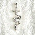 Pendentif épée et serpent en alliage argenté vintage sur fond de tissu blanc - Argenté