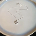 Dettaglio del ciondolo quadrato vuoto con zircone placcato oro 18k su collana argento - Argento