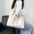 Detailed shot of a beige canvas shoulder bag with colorful polka dots on a model - Colorful Polka Dots