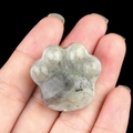 Handheld labradorite cat paw stone sculpture with natural grey-green speckled texture - Labradorite