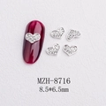 Detail view of 8.5x6.5mm silver heart nail charms with rhinestones on red cat eye nail art - Silver Heart Full Rhinestone Style(8716)