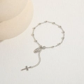 Detailed view of silver cross and saint medal pendant on beaded chain bracelet - Platinum Plated Silver
