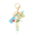 Letter T resin keychain with green sequins, dried flower, tassel and butterfly charm - Letter T