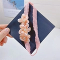 Detail of pink fabric flowers with faux pearls on a baby headband held by hand - Hair Band / Orange Pink Flower